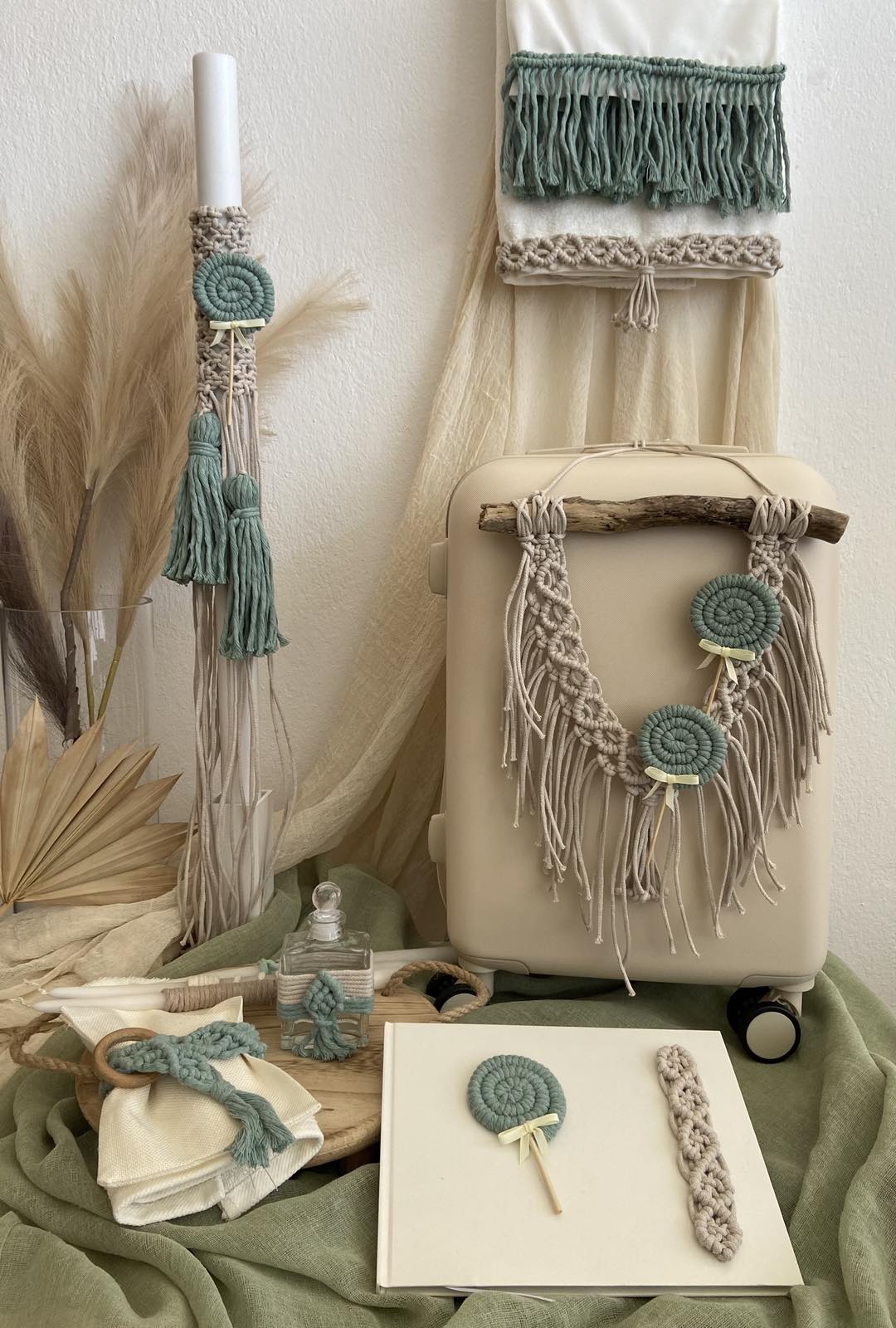 Beige suitcase with decorative tassels and macrame patterns on a neutral background