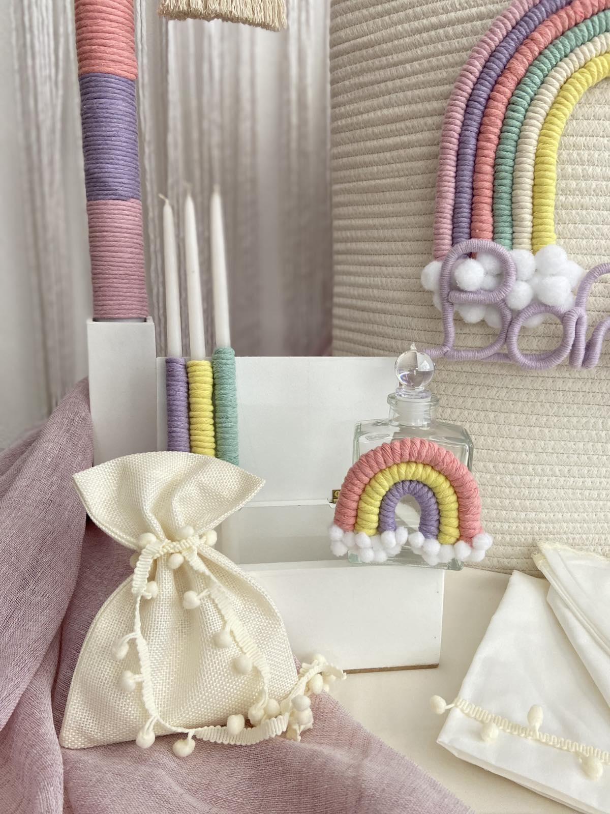 Decorative items including a rainbow-themed bottle and a drawstring bag on a textured surface.